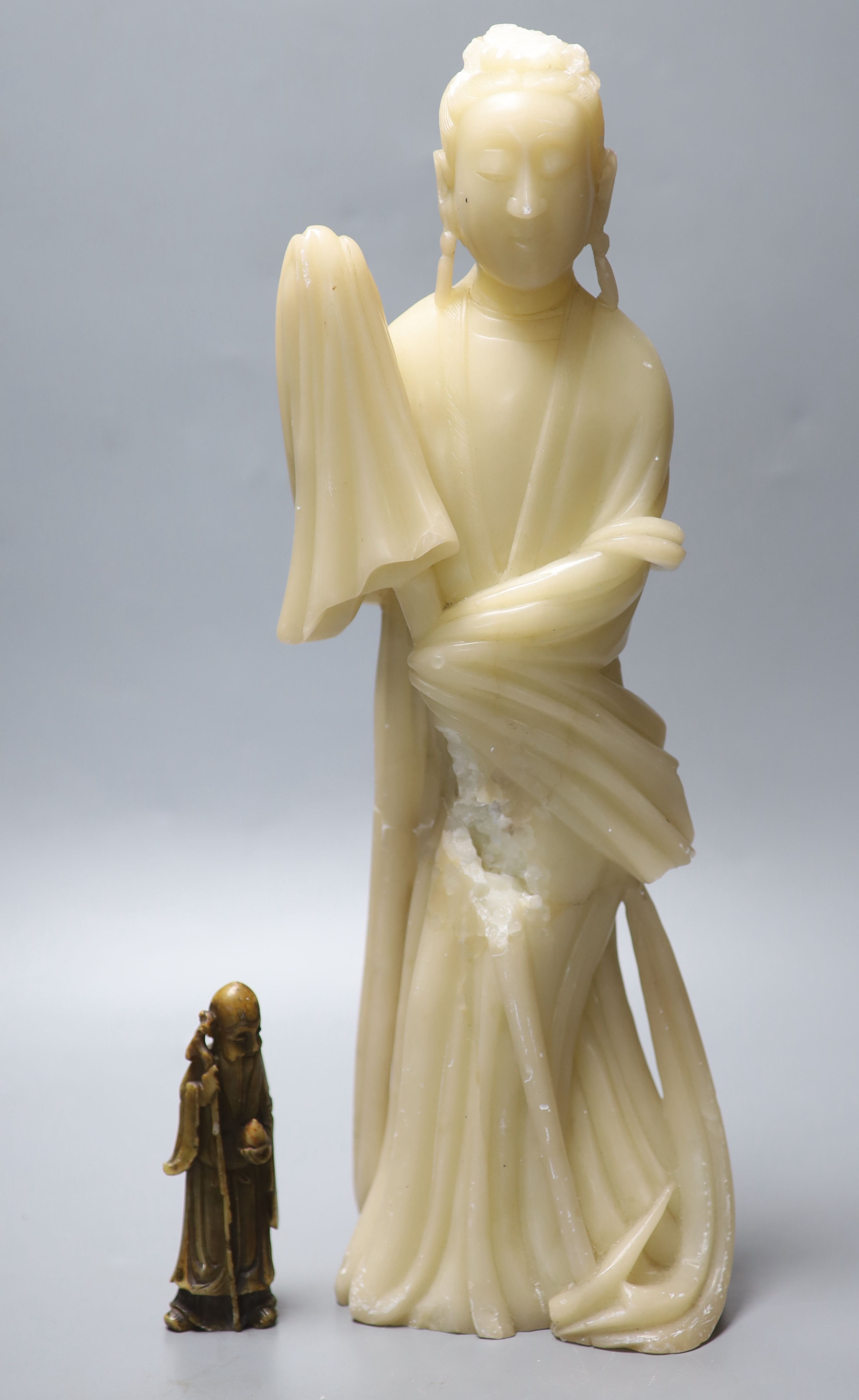 A large Chinese cream soapstone figure of an immortal, 41.5cm, (damaged) and a smaller 19th century Chinese russet soapstone figure of